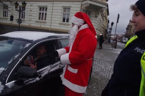 Mikołaj rozmawia z kierowcą w tle miasto