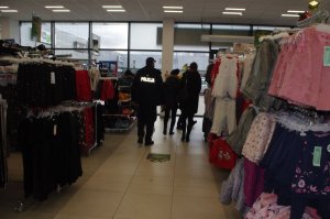 policjantka w sklepie w tle wnętrze sklepu odzieżowego