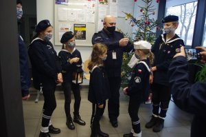 Harcerze u policjantów w tle hol komendy