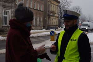 policjant rozmawia z pieszą  w tle ulica