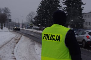 policjantka obserwuje drogę w tle ulica i pojazdy