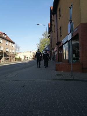 policjanci patrolują ulice miasta w tle zabudowania