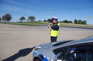 policjant sprawdza prędkość pojazdu w tle ulica