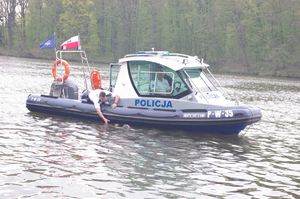 ratownicy policyjni wciągają tonącego na łódź
