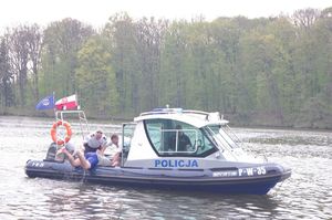 policjanci ratują z wody topielca w tle jezioro i policyjna łódź