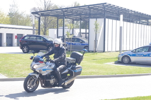 policjant na motocyklu  w tle teren jednostki