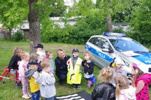 policjantka rozmawia z dziećmi w tle teren przedszkola
