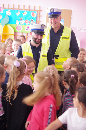 policjanci w otoczeniu dzieci w tle sala