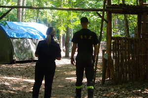 policjantka i strażak wchodzą do obozu w tle namioty