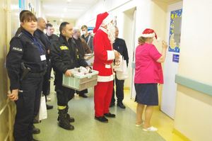 Mikołaj z funkcjonariuszami na oddziale, w tle pacjenci i sale szpitalne, korytarze szpitala