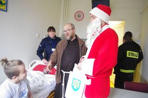 Mikołaj z funkcjonariuszami na oddziale, w tle pacjenci i sale szpitalne, korytarze szpitala