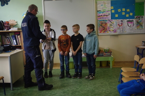 Policjanci dzielnicowi uczą dzieci pierwszej pomocy w tle klasa lekcyjna
