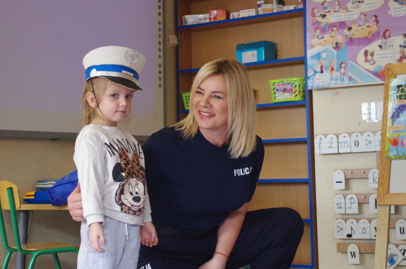 policjantka rozmawia z przedszkolakami w tle sala