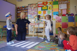 policjantka rozmawia z przedszkolakami w tle sala