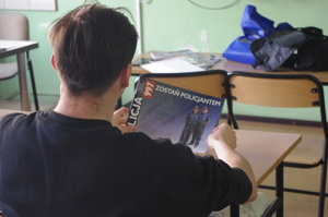 uczeń trzyma policyjne czasopismo w tle tablica