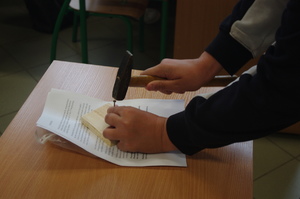 policjantka rozmawia z uczniami,  w tle klasa