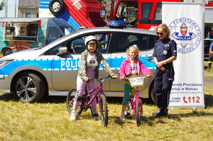 policjantka rozmawia z rowerzystami w tle radiowóz