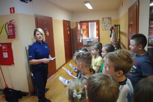 policjantka rozmawia z uczniami w tle korytarz szkoły