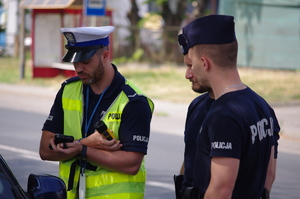 policjanci w trakcie patrolu w tle jezioro