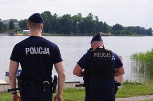policjanci w trakcie patrolu w tle jezioro