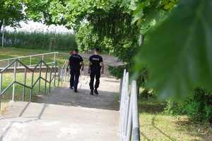 policjanci w trakcie patrolu w tle jezioro