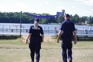 policjanci kontrolują kąpielisko w tle jezioro