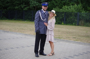 policjant z partnerką, w tle zieleń