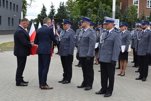 nagrody dla policjantów w tle teren komendy i policjanci