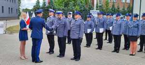 komendant wręcza nagrody policjantom w tle policjanci i goście