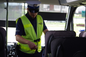 policjant w autobusie w tle szyba