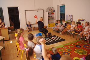 policjantka rozmawia z dziećmi w tle sala przedszkolna