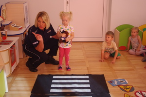 policjantka rozmawia z dziećmi w tle sala przedszkolna