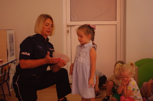 policjantka rozmawia z dziećmi w tle sala przedszkolna