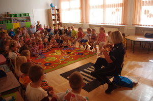 policjantka rozmawia z dziećmi w tle sala przedszkolna