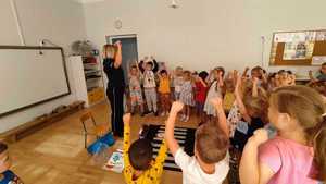 policjantka rozmawia z przedszkolakami w tle sala
