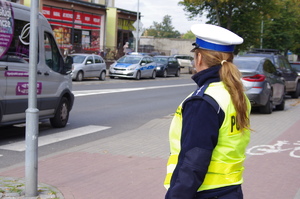 policjantka stoi przy przejściu w tle pojazdy