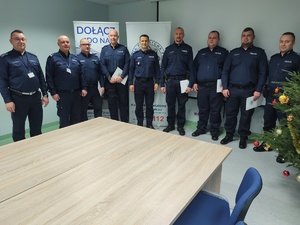 komendant wręcza wyróżnienia w tle ściana i choinka