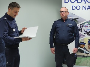 komendant wręcza wyróżnienia w tle ściana i choinka