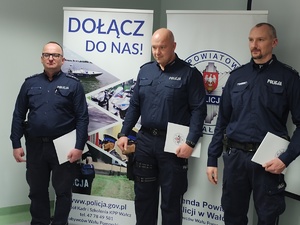 komendant wręcza wyróżnienia w tle ściana i choinka