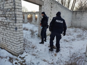 policjanci sprawdzają miejsca przebywania osób bezdomnych, w tle pustostan