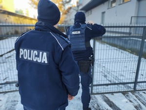 policjanci sprawdzają miejsca przebywania osób bezdomnych, w tle budynek