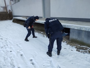 policjanci sprawdzają miejsca przebywania osób bezdomnych, w tle miejsce przebywania osoby bezdomnej