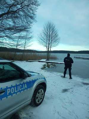 radiowóz w tle policjant kontrolujący jezioro