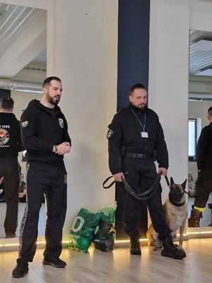 przewodnik opowiada o swojej pracy i pracy pas służbowego w tle dzieci , strażacy, pies i wyposażenie siłowni