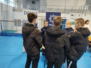 policjantki rozmawiają z odwiedzającymi targi  w tle wnętrze hali sportowej i inni wystawcy