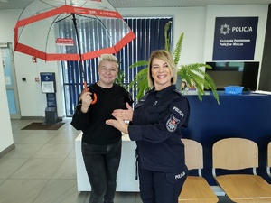 policjantka i kobieta z parasolem w tle hol komendy