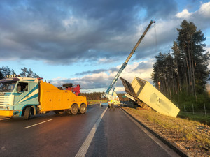 pojazd ciężarowy wyciągany z rowu przez dźwig w tle ulica