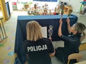 policjantki przedstawiają kukiełki w tle dzieci