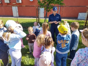 policjantka rozmawia z dziećmi tle ogrodznie