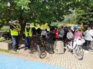 policjanci rozmawiają z uczniami w tle zieleń